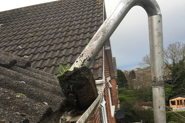 An image of a gutter being cleaned with a vacuum